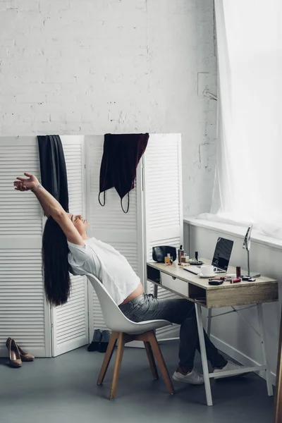 Young transgender woman stretching while working at home — Stock Photo