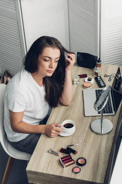 Vista ad alto angolo della giovane donna transgender freelancer con tazza di caffè seduta sul posto di lavoro a casa — Foto stock