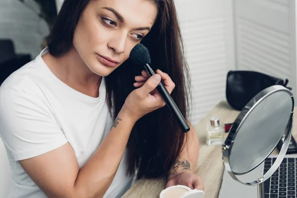Close-up portrait of transgender woman doing makeup at workplace at home — Stock Photo
