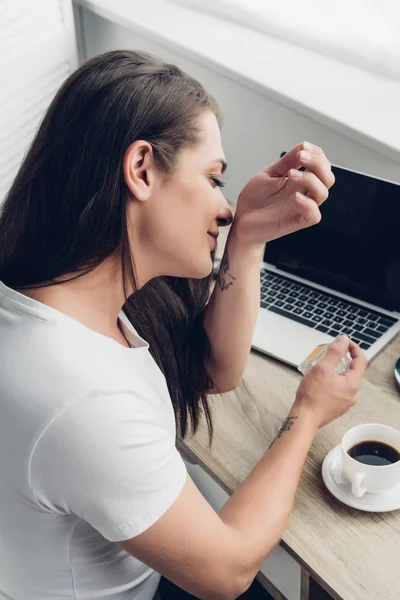 Young transgender woman smelling perfume on wrist at home — Stock Photo