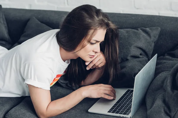 Jovem transgênero freelancer mulher trabalhando com laptop no sofá em casa — Fotografia de Stock