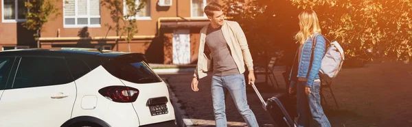 Couple of tourists with backpack and baggage near car on street — Stock Photo