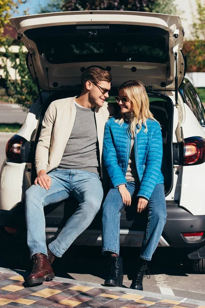 Paar lächelnde Touristen nahe Auto auf Straße — Stockfoto