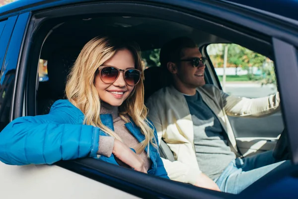 Sonriente pareja de turistas conduciendo coche mientras viajan juntos - foto de stock