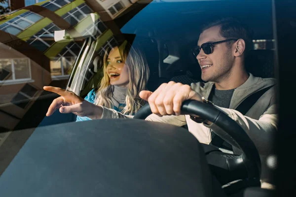 Улыбающаяся пара туристов за рулем автомобиля во время путешествия вместе — стоковое фото