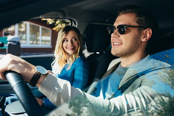 Donna sorridente al fidanzato guida auto durante le vacanze — Foto stock
