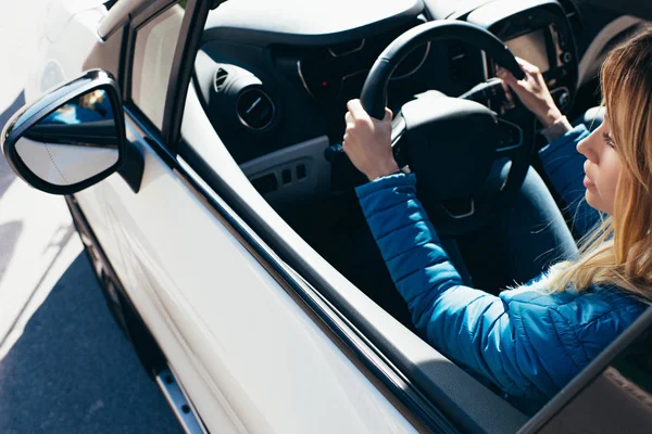 Visão lateral da jovem mulher com as mãos no volante carro de condução — Fotografia de Stock