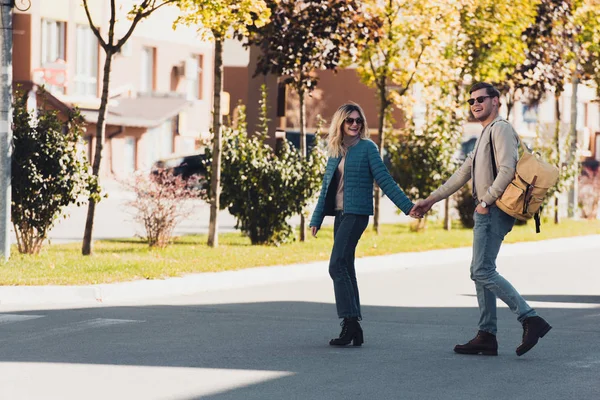 Couple holding hands while walking together in new city — Stock Photo