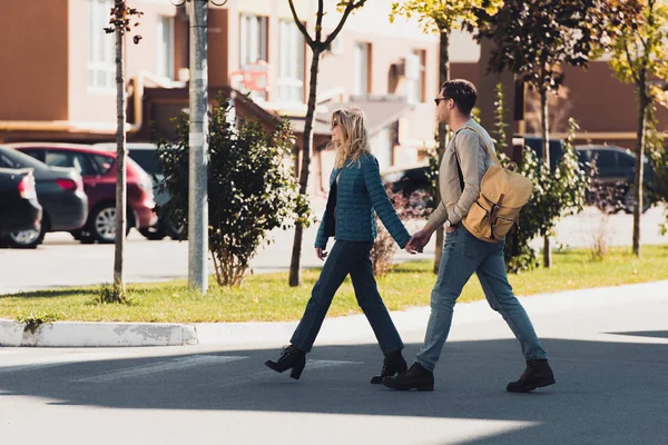 Couple holding hands while walking together in new city — Stock Photo