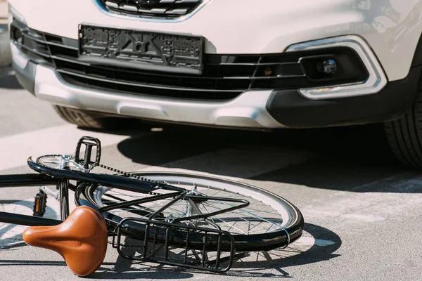 Vista de cerca de la bicicleta rota y el coche en la carretera, concepto de accidente de coche - foto de stock