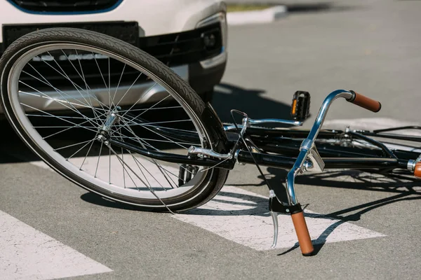 Close up view of broken bicycle and car on road, car accident concept — Stock Photo