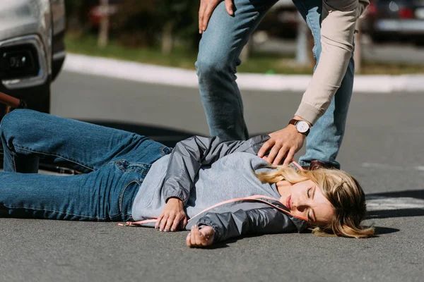 Частичный вид молодой женщины, сбитой водителем в машине на дороге, концепция ДТП — стоковое фото
