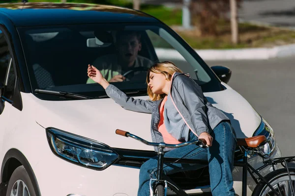 Jeune femme a été fauché par la voiture tout en conduisant vélo sur la route, concept d'accident de voiture — Photo de stock