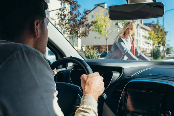 Conductor de coche esperando mientras la joven mujer cruza la carretera - foto de stock