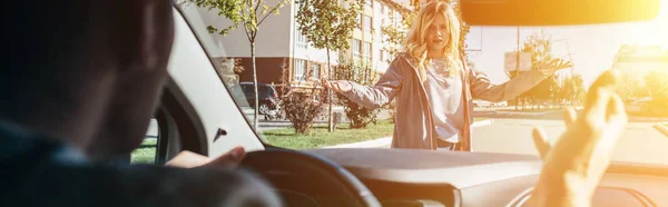 Young woman quarreling with car driver while crossing road — Stock Photo