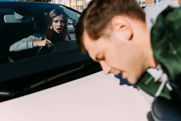 Donna scioccata in auto falciato giovane uomo sulla strada — Foto stock