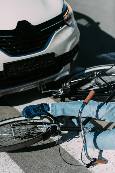 Visión parcial del ciclista masculino golpeado por el coche en la carretera, concepto de accidente de coche - foto de stock