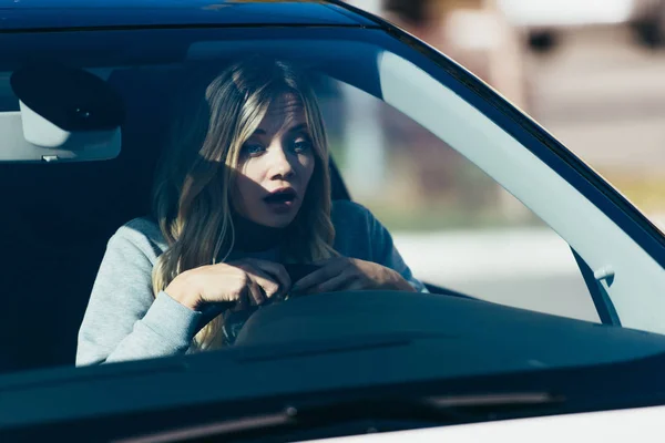 Портрет шокированной женщины, смотрящей на дорогу во время вождения автомобиля — стоковое фото