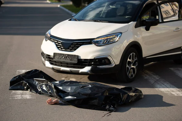 Vista de ángulo alto del cadáver y el automóvil en la carretera después de la colisión del vehículo de motor - foto de stock