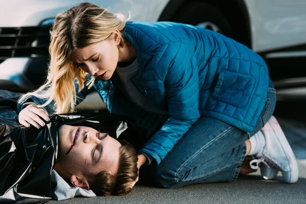 Young woman crying above dead man on road after traffic accident — Stock Photo