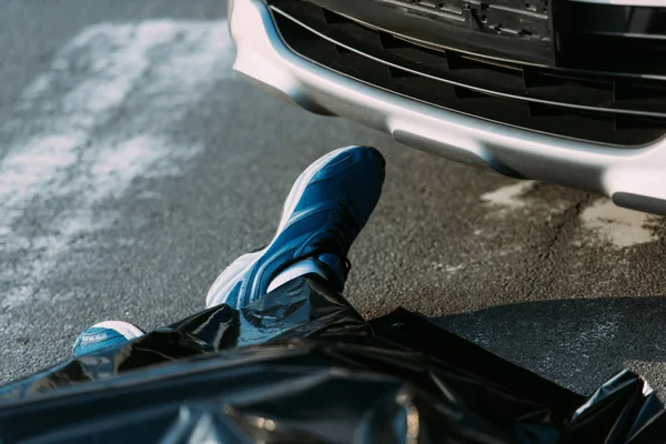 Cropped shot of dead man and car on road after motor vehicle collision — Stock Photo