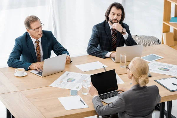 Деловые люди, сидящие за столом и ведущие дискуссии в офисе — стоковое фото