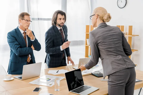 Insurance workers standing near table and having discussion in office — Stock Photo