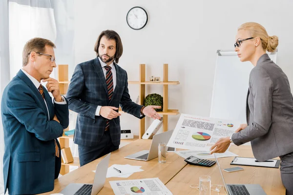 Insurance workers standing near table and having discussion in office — Stock Photo