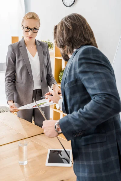 Jeune femme et homme debout à la réunion dans le bureau — Photo de stock