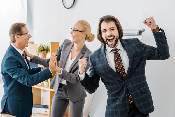 Felices agentes de seguros regocijándose mucho en el cargo - foto de stock