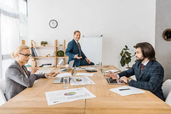 Empresários sentados à mesa durante reunião no escritório — Fotografia de Stock