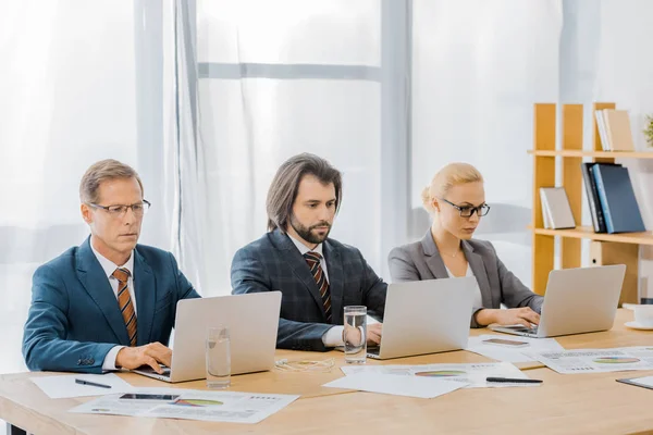 Insurance workers sitting at table and using laptops in office — Stock Photo