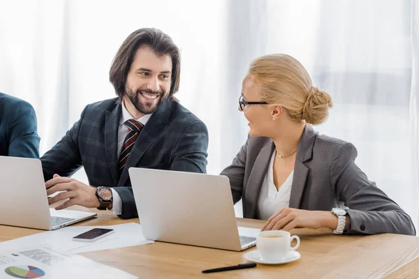 Усміхнені ділові люди говорять на зустрічі в офісі — стокове фото