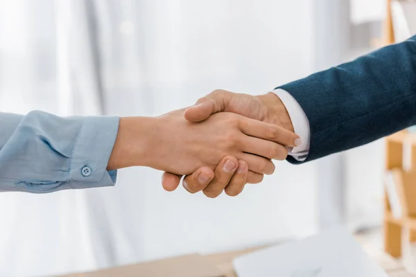 Nahaufnahme einer Frau und eines Versicherungsvertreters beim Händeschütteln im Büro — Stockfoto