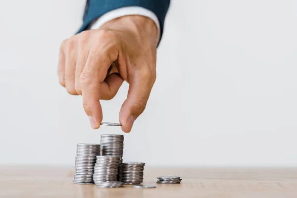 Mano masculina recogiendo moneda de plata de mesa de madera - foto de stock