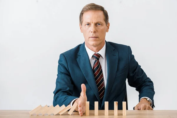 Sérieux homme d'affaires avec des blocs jeu de bois dans le bureau, concept d'assurance — Photo de stock