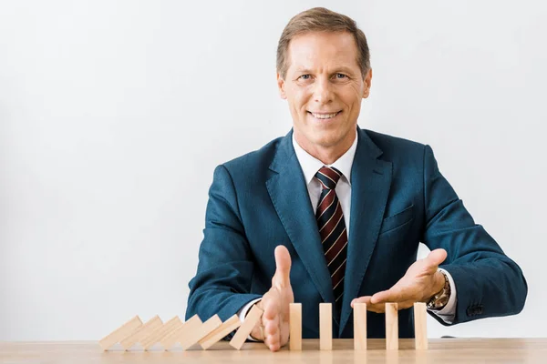 Улыбающийся бизнесмен с деревянными блоками игры в офисе, концепция страхования — стоковое фото
