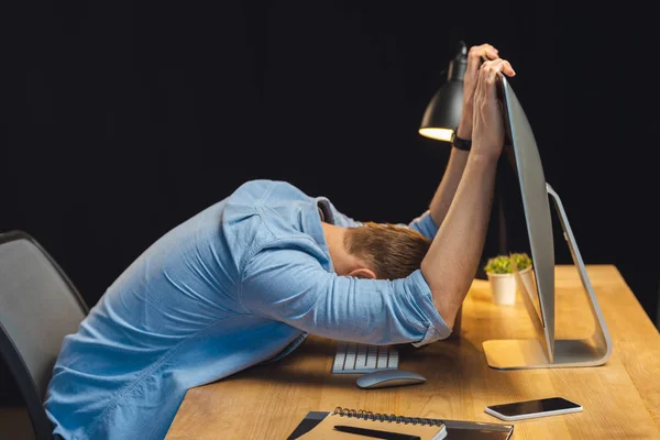 Empresário dormindo à mesa com computador e smartphone durante a noite no escritório — Fotografia de Stock