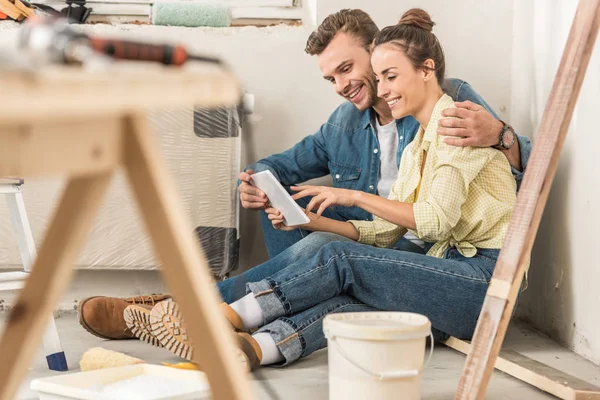 Glückliches junges Paar nutzt digitales Tablet bei Renovierung im neuen Haus — Stockfoto