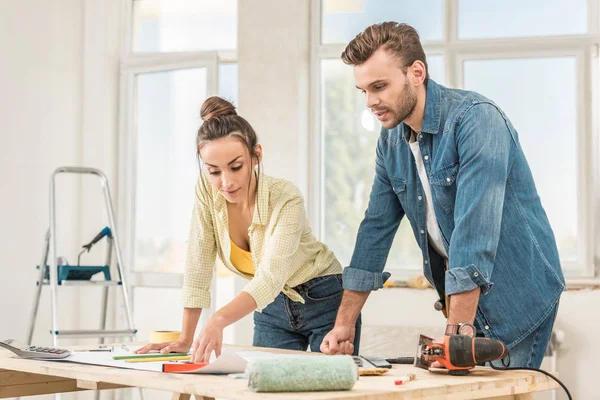 Junges Paar schaut sich bei Hausreparatur Bauplan an — Stockfoto