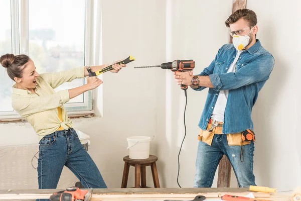 Happy young couple having fun with tools during home improvement — Stock Photo