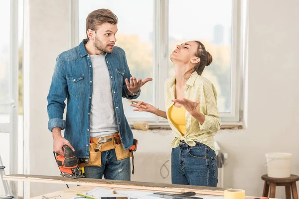 Emotionales junges Paar streitet bei Hausbau — Stockfoto