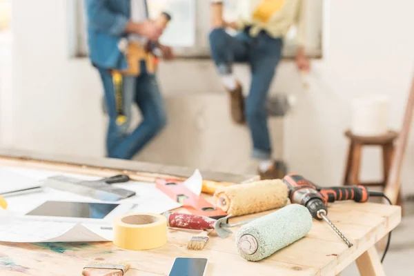 Vista de cerca de las herramientas y dispositivos digitales en la mesa durante la reparación de la casa - foto de stock