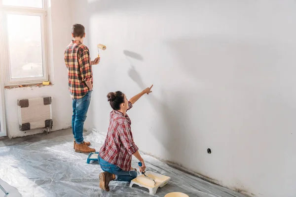 Vista de ángulo alto de la pared de pintura de pareja joven en casa nueva - foto de stock