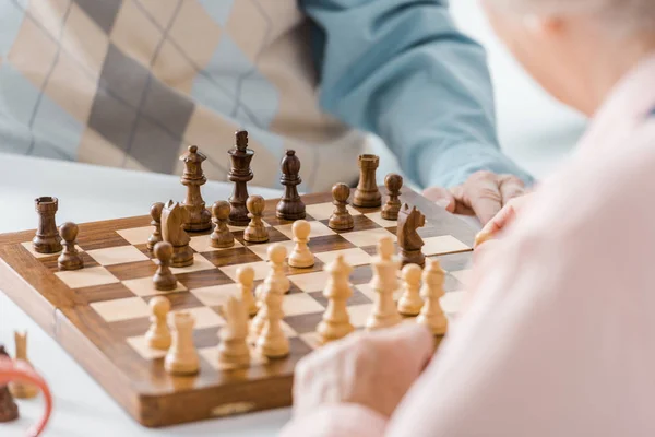 Gros plan de couple de personnes âgées jouant aux échecs ensemble — Photo de stock