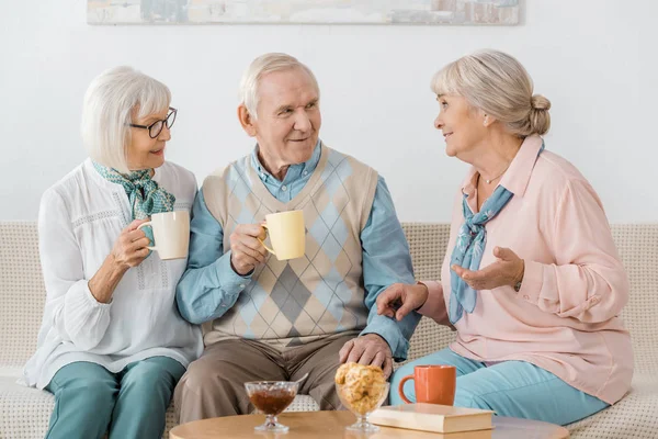 Personas mayores tomando café y hablando en un asilo de ancianos - foto de stock