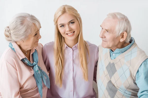 Giovane donna sorridente che abbraccia i genitori anziani — Foto stock