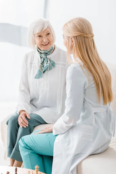 Jovem médico feminino conversando com a mulher idosa na clínica — Fotografia de Stock