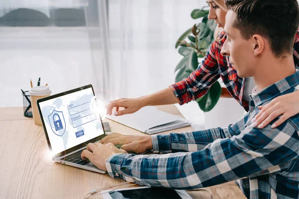 Businesswoman pointing at laptop with security password on screen while taking part in webinar together with colleague in office — Stock Photo