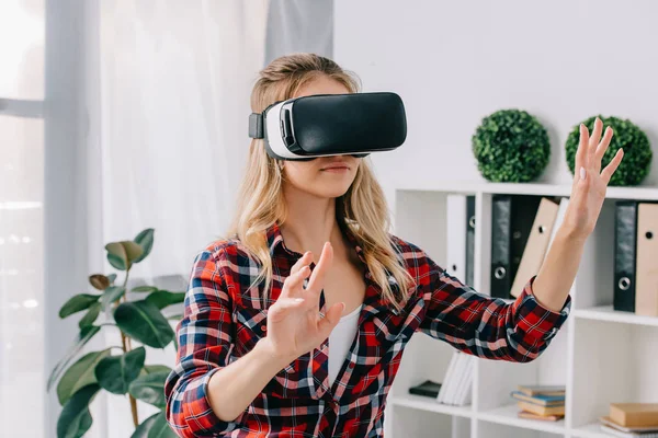 Young woman in virtual reality headset gesturing in room — Stock Photo